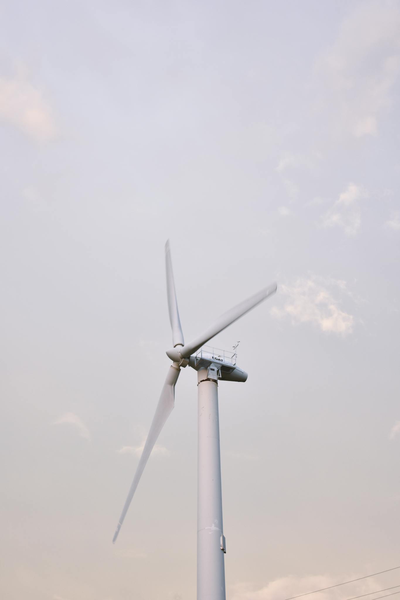 A solitary wind turbine standing against a clear sky, symbolizing renewable energy in Thailand.